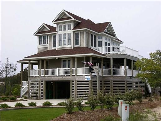 Diseño de fachada gris costera grande de dos plantas con revestimiento de madera y tejado a dos aguas