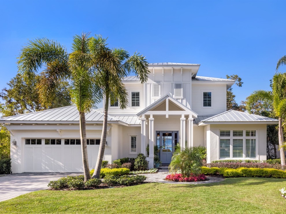 Inspiration for a coastal white two-story house exterior remodel in Orlando with a clipped gable roof