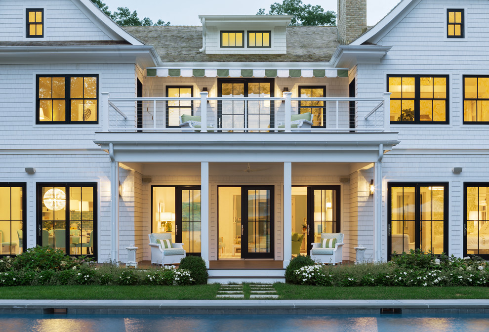Cette photo montre une grande façade de maison blanche chic en bois à un étage.