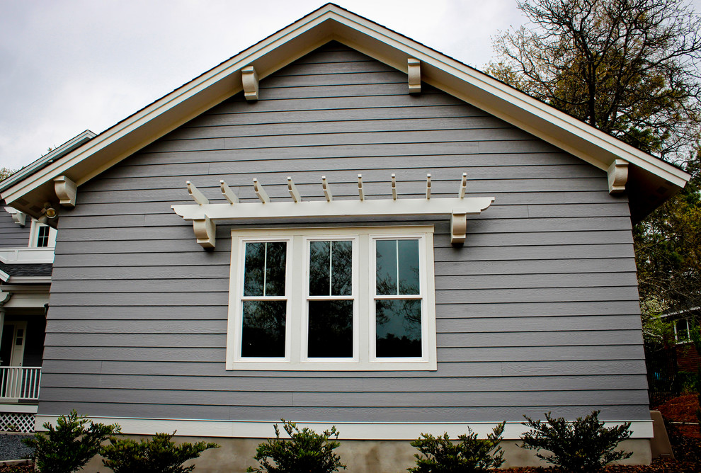Idée de décoration pour une grande façade de maison bleue marine en bois à un étage avec un toit à deux pans.