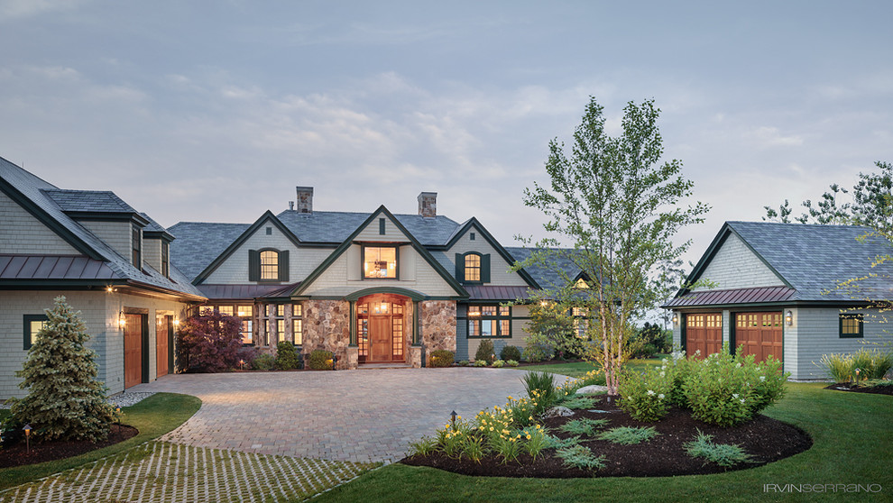 На фото: большой, двухэтажный, бежевый дом в морском стиле с облицовкой из камня и мансардной крышей с