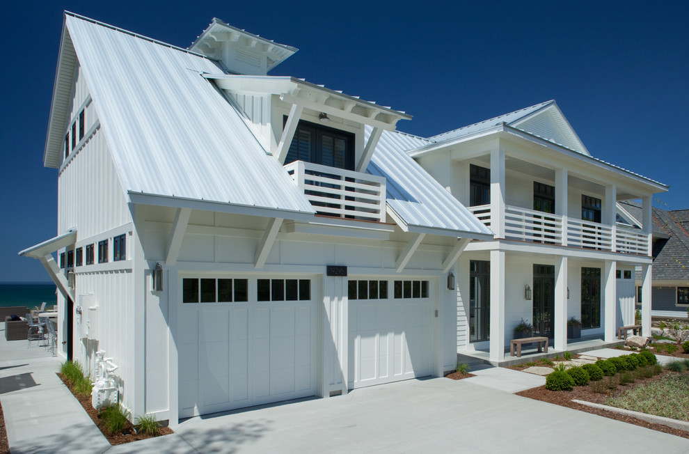 На фото: двухэтажный, белый частный загородный дом среднего размера в морском стиле с облицовкой из винила, двускатной крышей и металлической крышей с