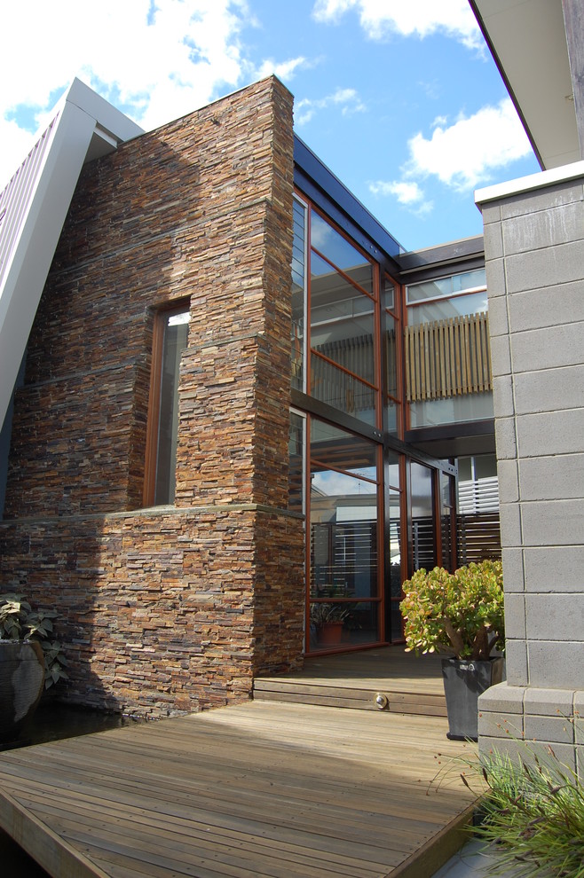 Immagine della facciata di una casa contemporanea a due piani di medie dimensioni con rivestimento in pietra