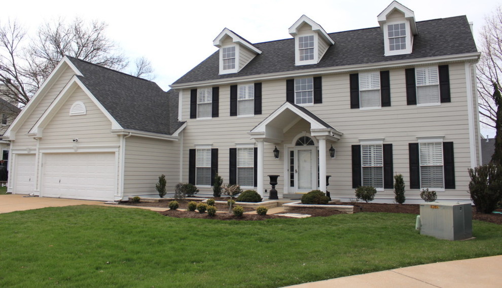 Example of a large classic beige two-story concrete fiberboard house exterior design in St Louis