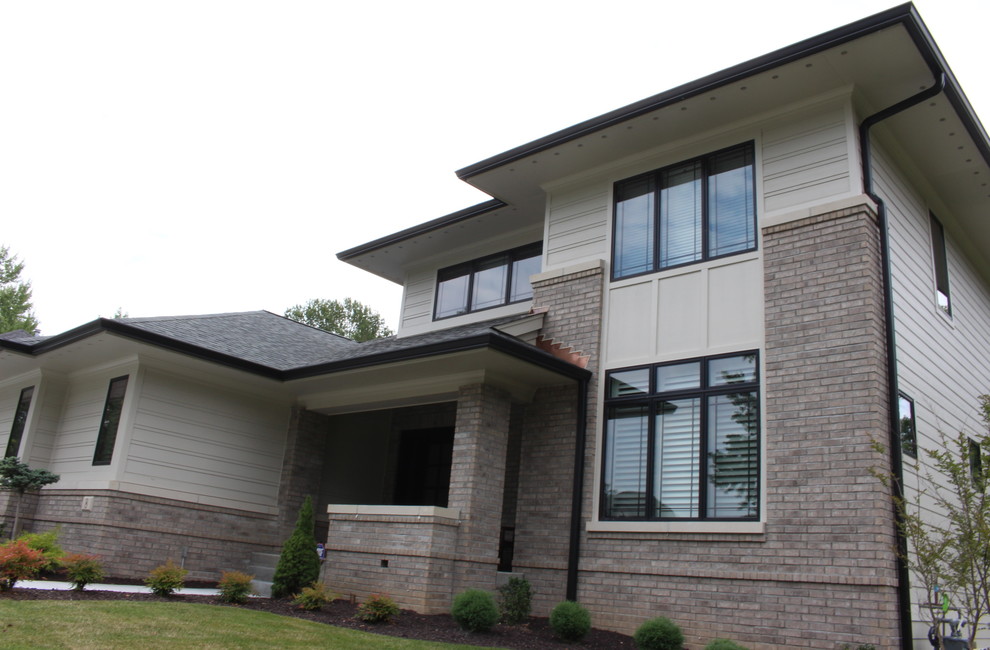 Großes, Zweistöckiges Modernes Einfamilienhaus mit Faserzement-Fassade, beiger Fassadenfarbe, Walmdach und Schindeldach in St. Louis