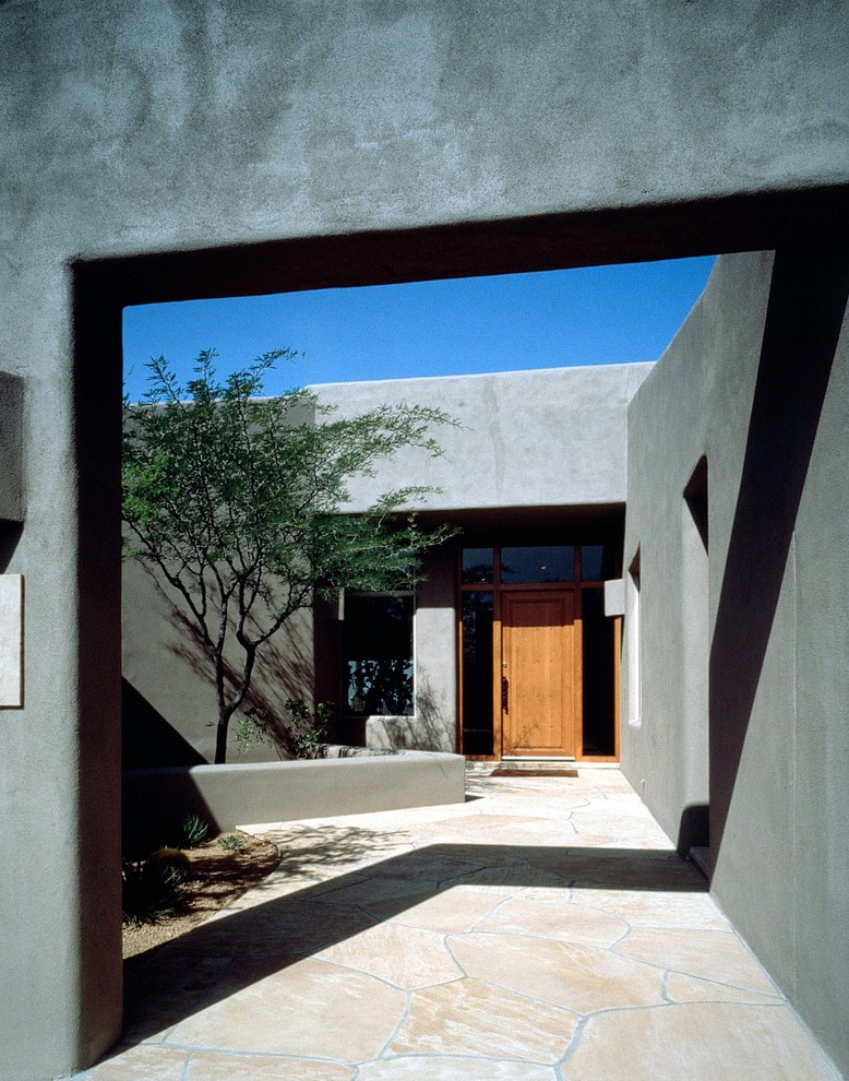 Aménagement d'une façade de maison grise contemporaine à un étage avec un revêtement mixte et un toit plat.