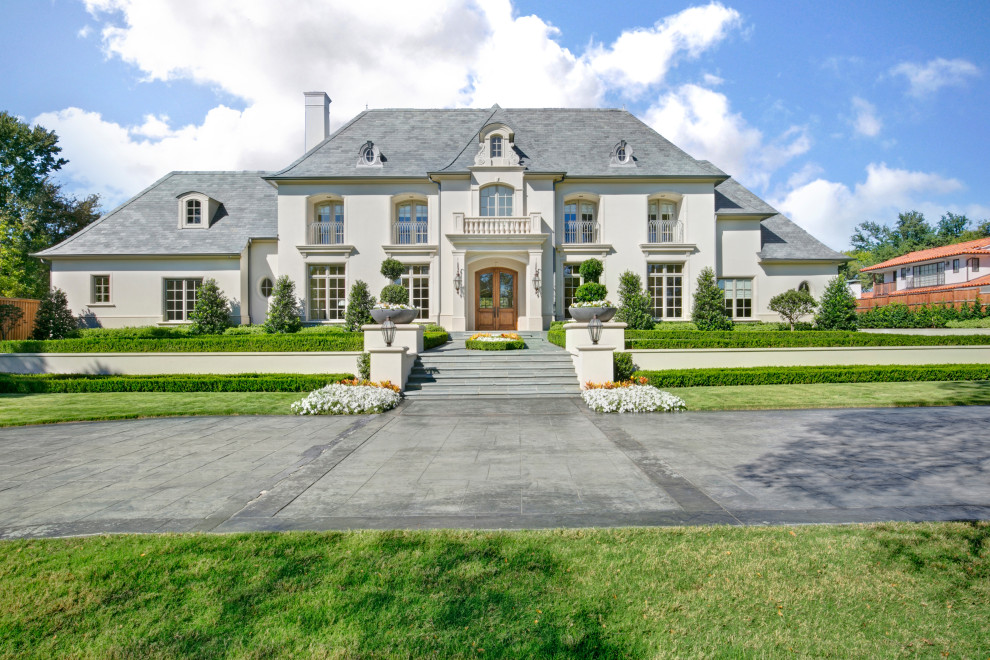 Inspiration for a huge french country gray two-story stucco house exterior remodel in Dallas with a hip roof and a shingle roof