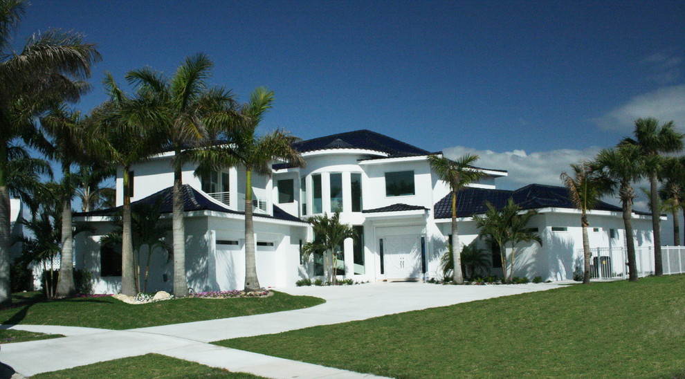 Ejemplo de fachada de casa blanca actual grande de dos plantas con revestimiento de estuco