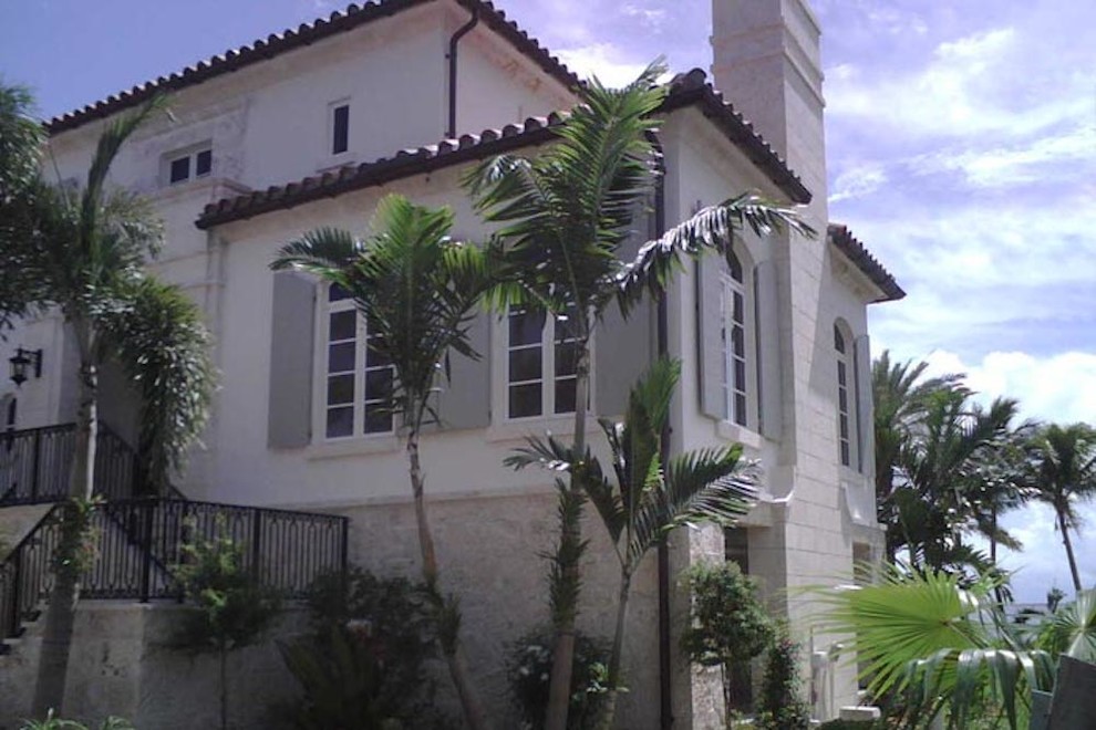 Diseño de fachada de casa blanca exótica grande de dos plantas con revestimientos combinados, tejado a cuatro aguas y tejado de teja de barro