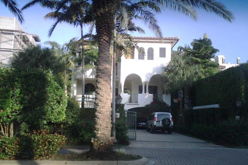 Inspiration for a large tropical white two-story stucco house exterior remodel in Miami with a tile roof