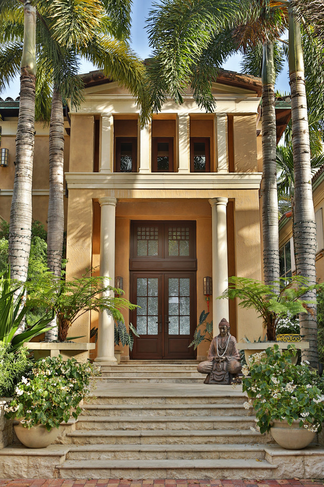 Пример оригинального дизайна: большой, двухэтажный, бежевый частный загородный дом в средиземноморском стиле с облицовкой из цементной штукатурки, двускатной крышей и черепичной крышей