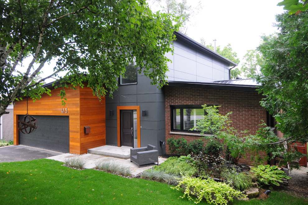 Réalisation d'une façade de maison marron minimaliste de taille moyenne et à un étage avec un revêtement mixte et un toit plat.