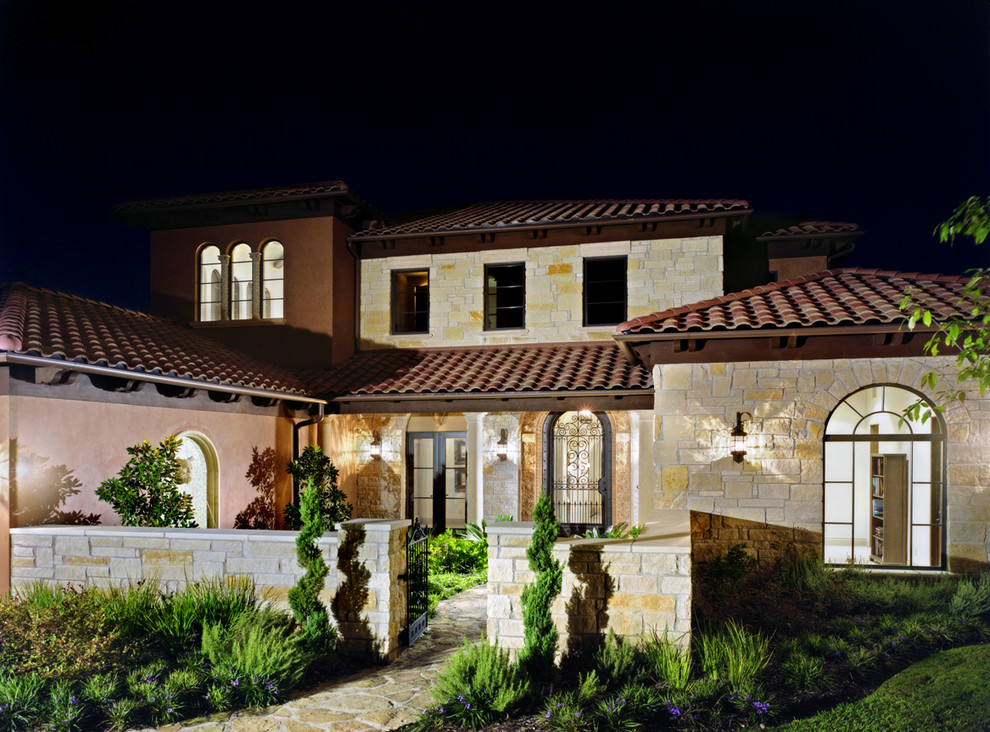 Design ideas for a mediterranean house exterior in Austin with stone cladding.