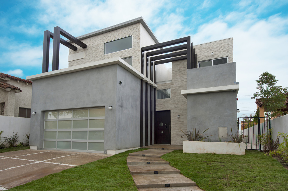 Стильный дизайн: двухэтажный, серый, большой дом в современном стиле с облицовкой из цементной штукатурки и плоской крышей - последний тренд