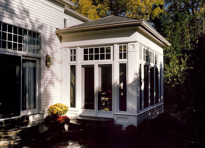 Imagen de fachada de casa blanca grande de dos plantas con revestimiento de vinilo, tejado a cuatro aguas y tejado de metal