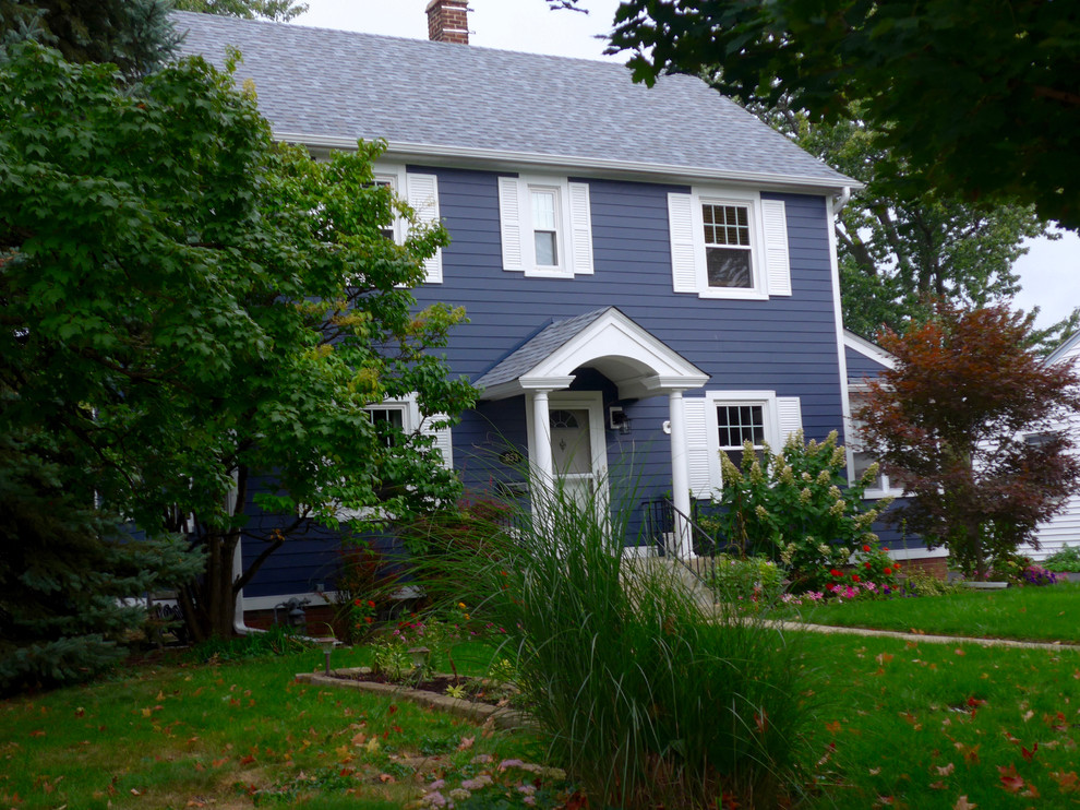 На фото: двухэтажный, синий частный загородный дом среднего размера в классическом стиле с облицовкой из ЦСП, двускатной крышей и крышей из гибкой черепицы