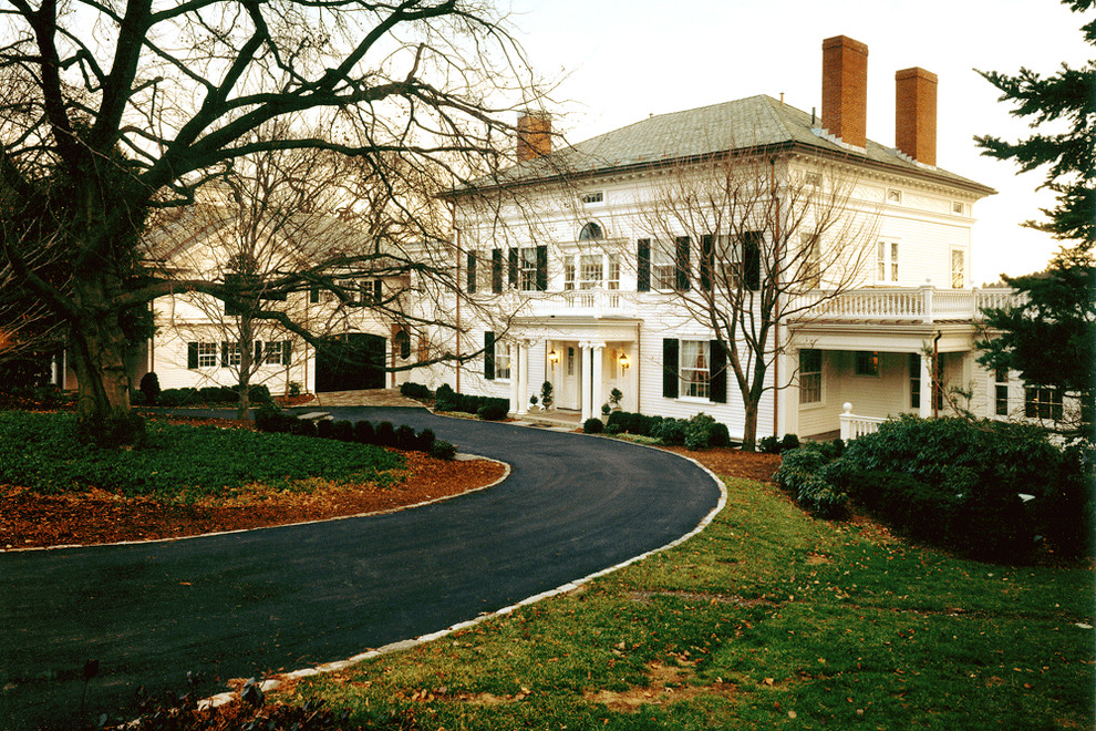 Пример оригинального дизайна: большой, двухэтажный, белый дом в классическом стиле с вальмовой крышей