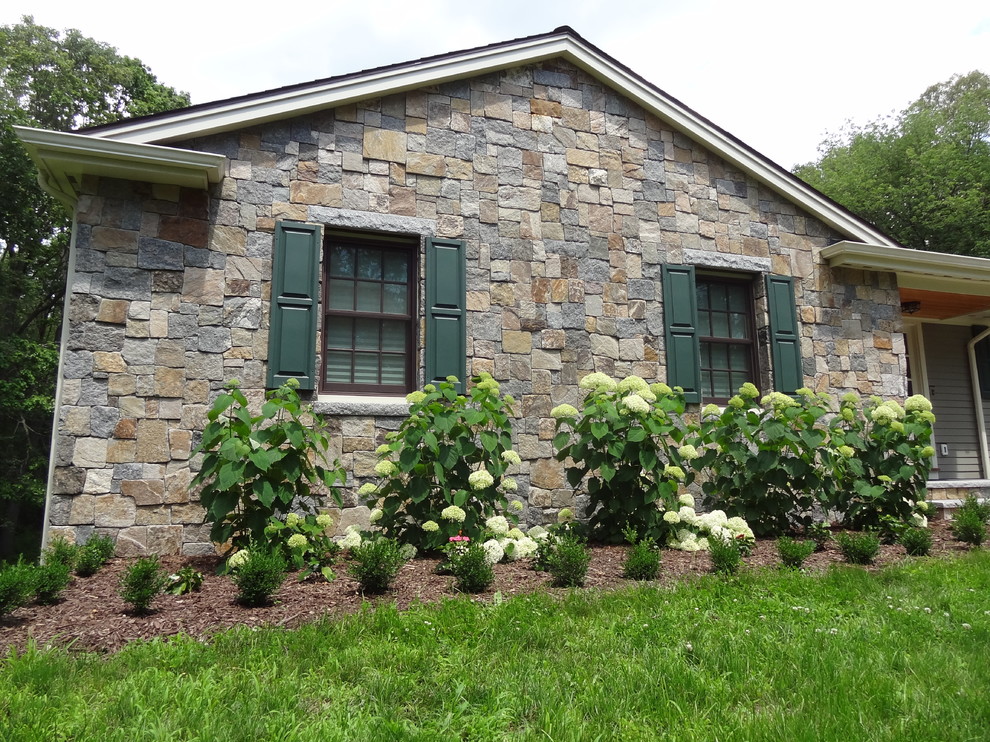 Inspiration pour une façade de maison verte traditionnelle en pierre.