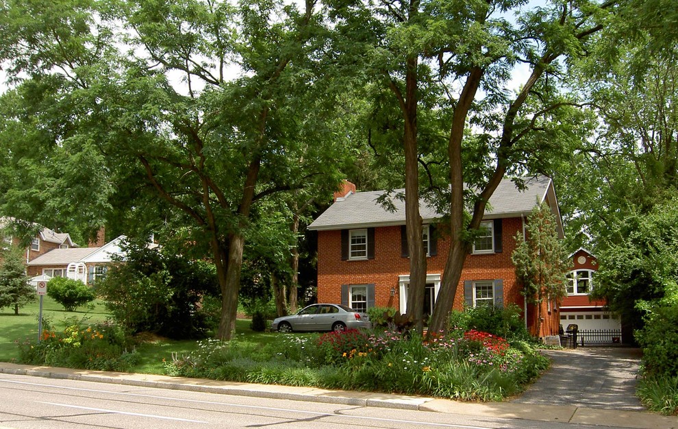 Esempio della facciata di una casa rossa american style a due piani di medie dimensioni con rivestimento con lastre in cemento e tetto a capanna