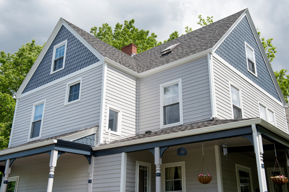 Пример оригинального дизайна: серый частный загородный дом в классическом стиле с облицовкой из ЦСП, двускатной крышей и крышей из гибкой черепицы