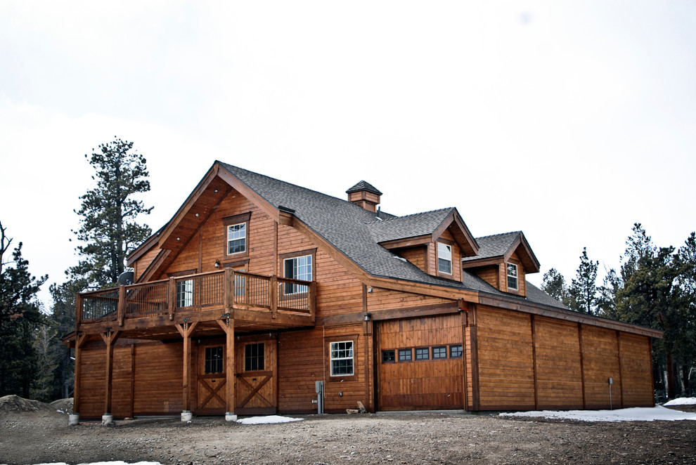 На фото: большой, двухэтажный, деревянный, коричневый дом в классическом стиле с двускатной крышей