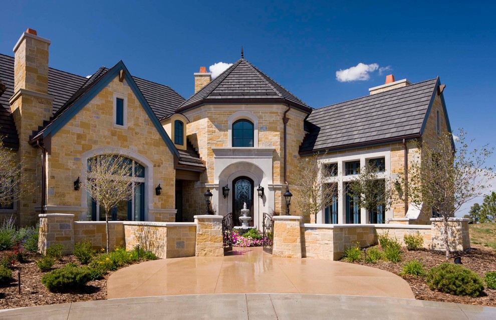 Large tuscan yellow stone exterior home photo in Denver