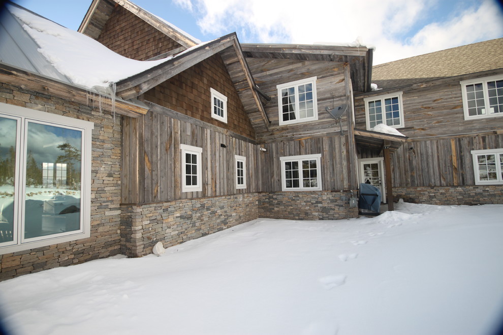 This is an example of a rustic house exterior in Denver with stone cladding.