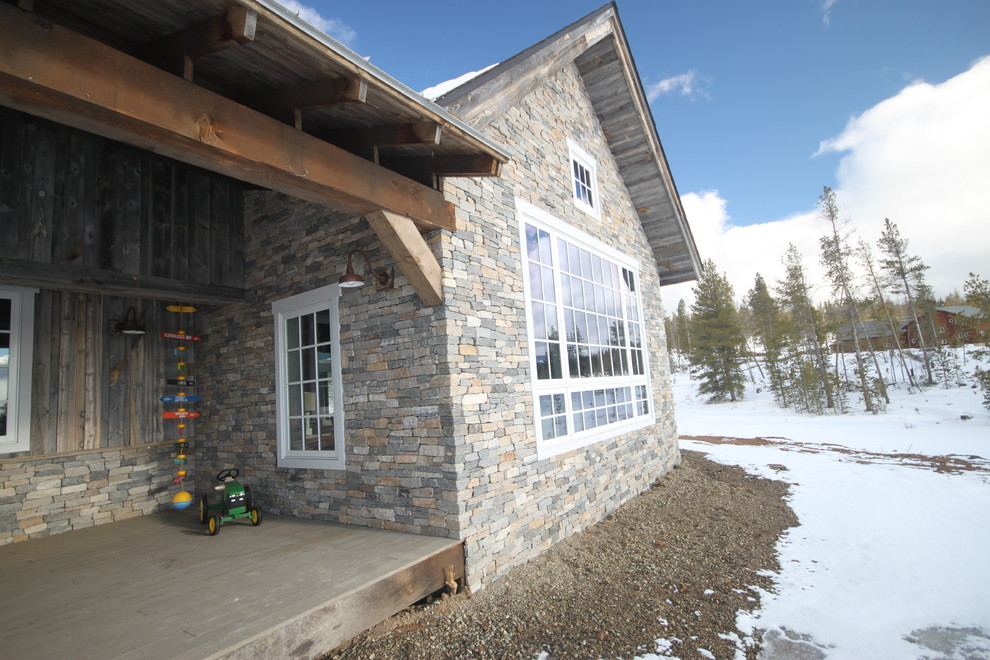 Inspiration for a rustic house exterior in Denver with stone cladding.