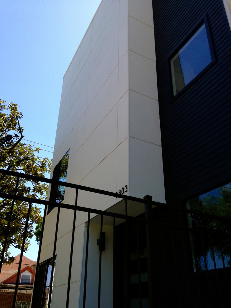 Minimalist white three-story concrete fiberboard flat roof photo in Houston