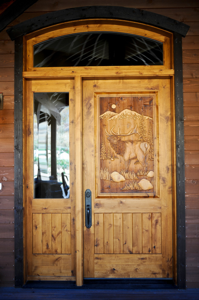 Immagine della villa grande rustica a due piani con rivestimenti misti