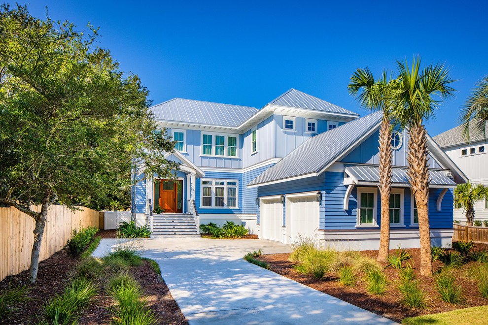 На фото: двухэтажный, синий частный загородный дом в морском стиле с металлической крышей с