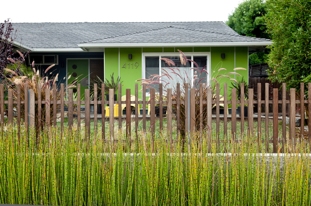 他の地域にあるミッドセンチュリースタイルのおしゃれな寄棟屋根の家 (緑の外壁) の写真