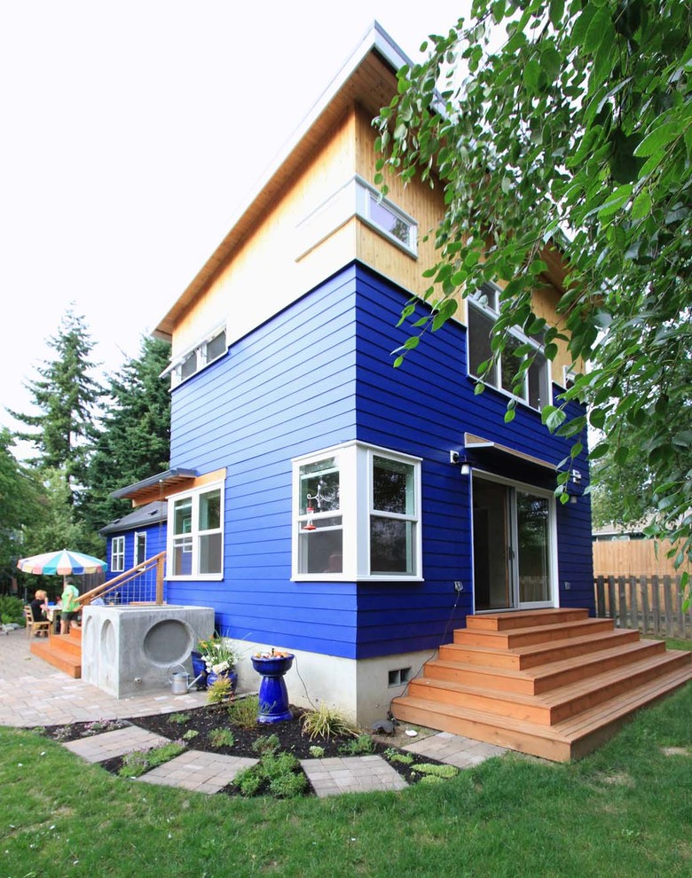 Bild på ett litet eklektiskt blått hus, med två våningar och blandad fasad