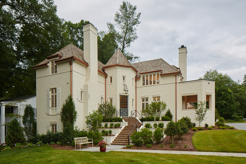 Exemple d'une façade de maison blanche moderne en brique à deux étages et plus.