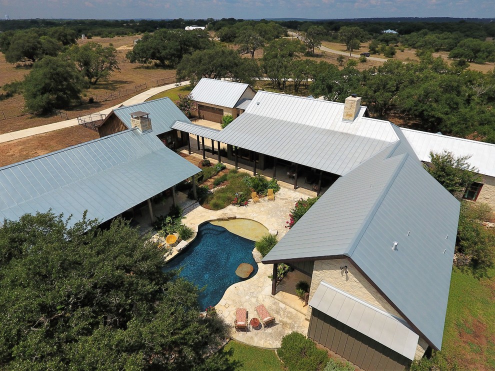 Immagine della villa beige country a un piano di medie dimensioni con rivestimento in pietra, tetto a capanna e copertura in metallo o lamiera
