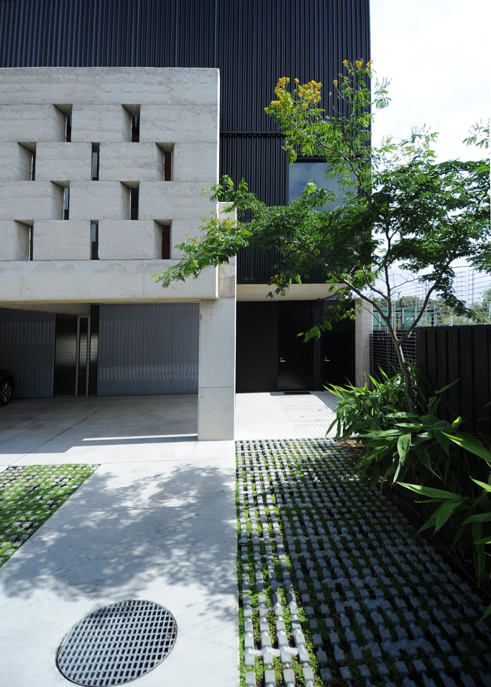 Diseño de fachada de casa urbana con revestimiento de hormigón y tejado plano