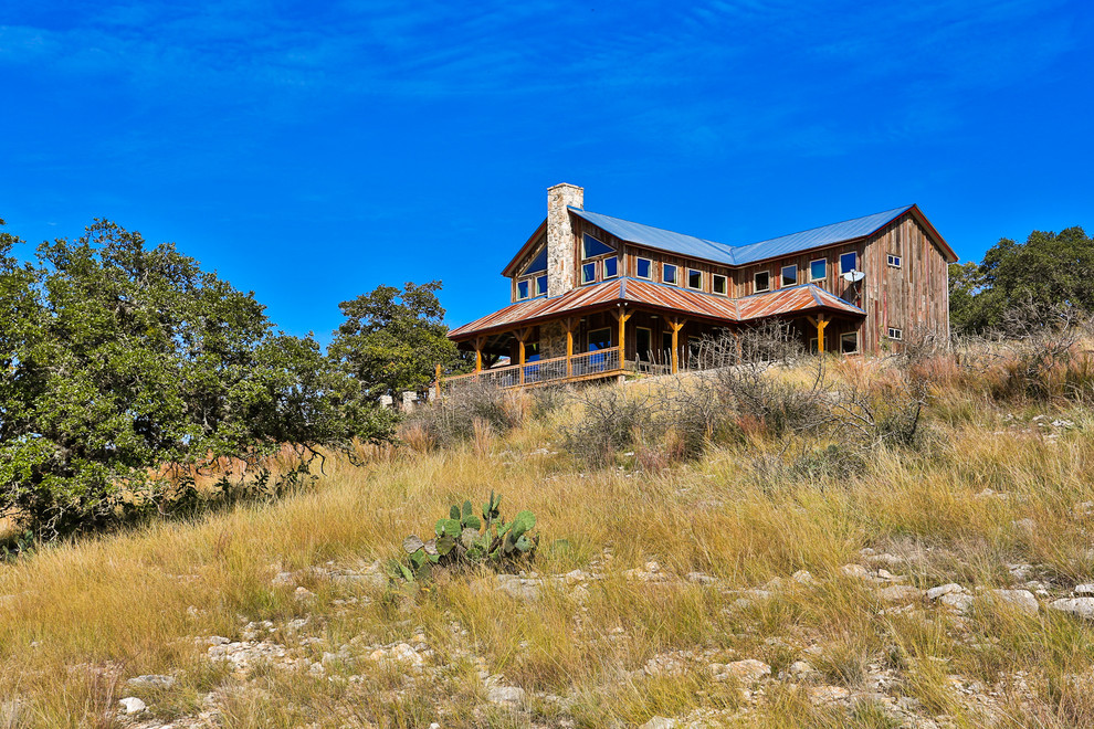 Mid-sized mountain style brown two-story wood gable roof photo in Austin