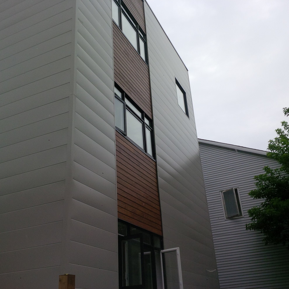 Design ideas for a gey contemporary house exterior in Ottawa with three floors and metal cladding.