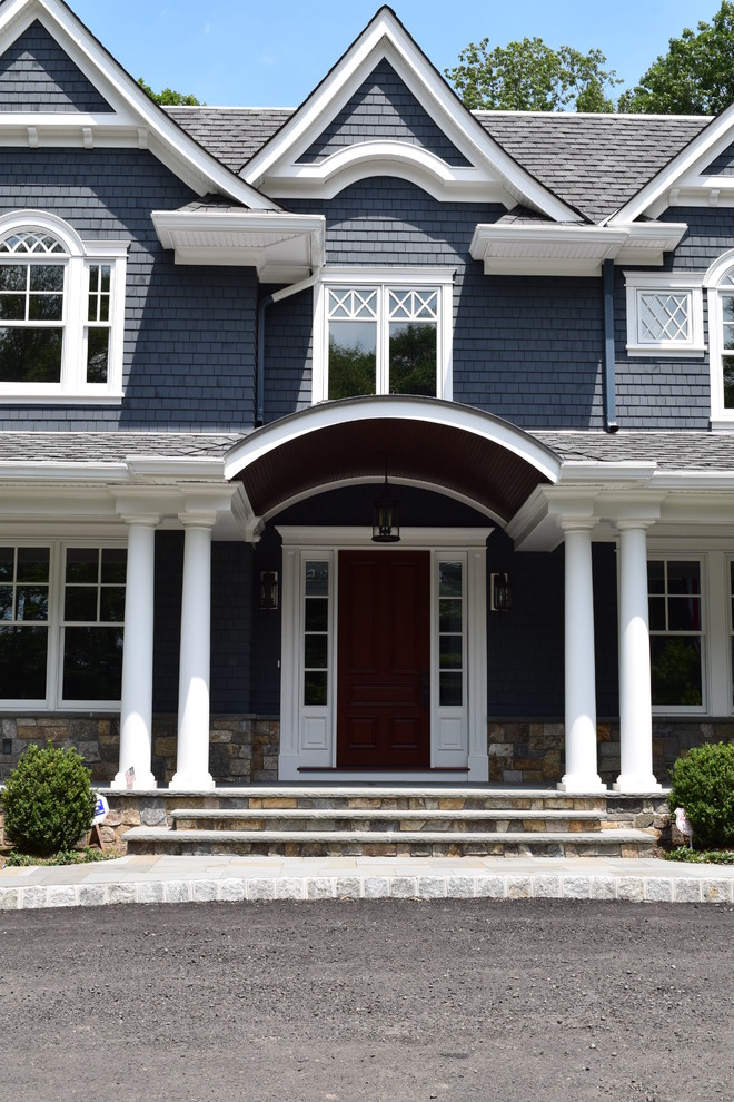 Inspiration for a large timeless blue two-story stone exterior home remodel in New York