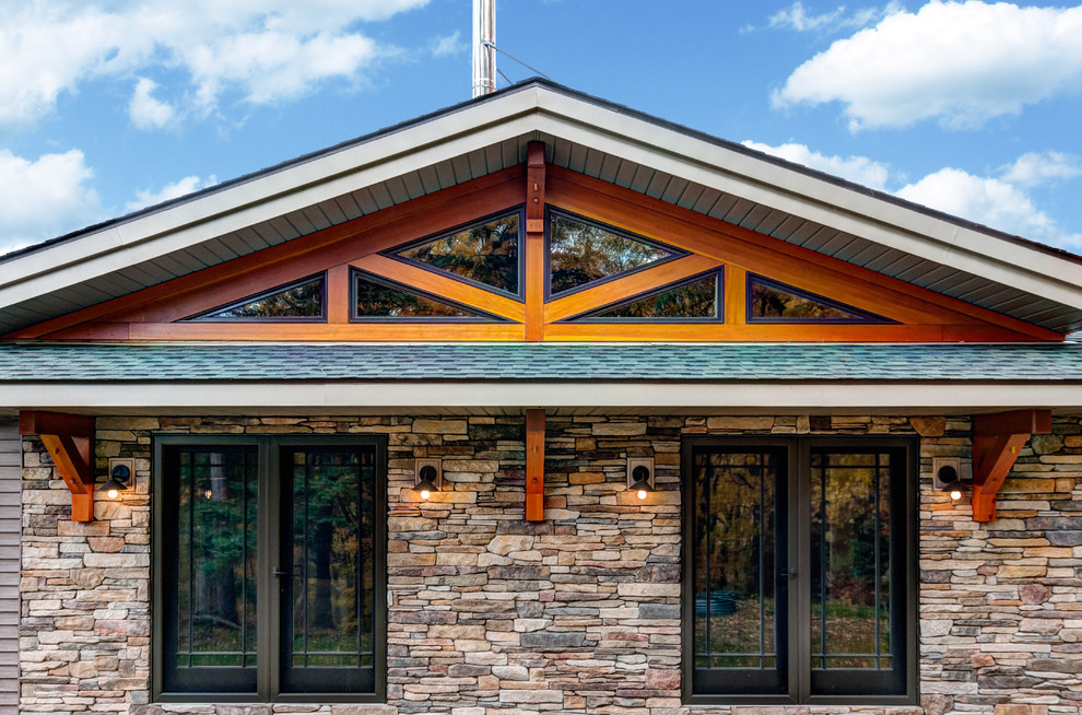 Cette photo montre une façade de maison craftsman en pierre de plain-pied avec un toit à deux pans.