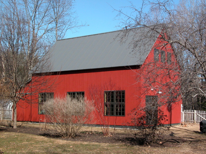 Inspiration for a mid-sized farmhouse red two-story wood gable roof remodel in Burlington