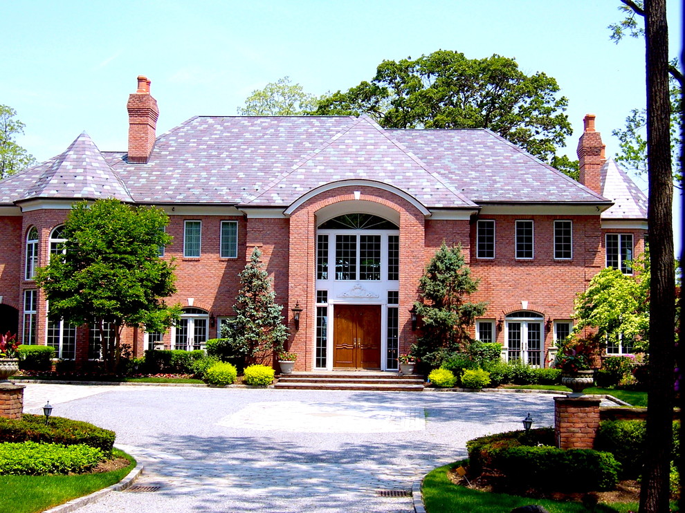 Idées déco pour une grande façade de maison marron classique en brique à un étage avec un toit à deux pans.