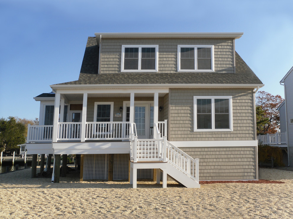 Photo of a medium sized and beige coastal bungalow house exterior in New York with vinyl cladding.