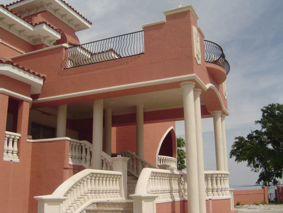 Esempio della facciata di una casa grande rossa mediterranea a tre piani con rivestimento in cemento e tetto a padiglione