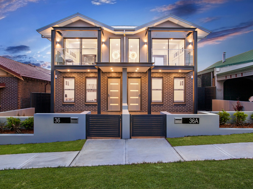 Mittelgroße, Zweistöckige Moderne Doppelhaushälfte mit Backsteinfassade, grauer Fassadenfarbe und Blechdach in Sydney