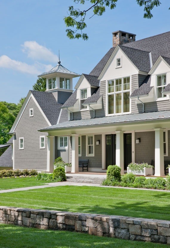 Imagen de fachada de casa gris de estilo americano grande de dos plantas con revestimiento de madera, tejado a dos aguas y tejado de teja de madera