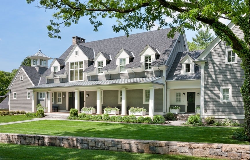 Ejemplo de fachada gris de estilo americano grande de dos plantas con revestimiento de madera y tejado a dos aguas