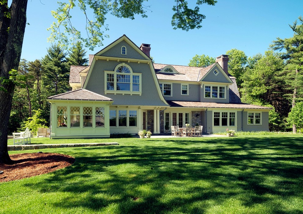 Cette photo montre une grande façade de maison grise chic en bois à deux étages et plus avec un toit à quatre pans.