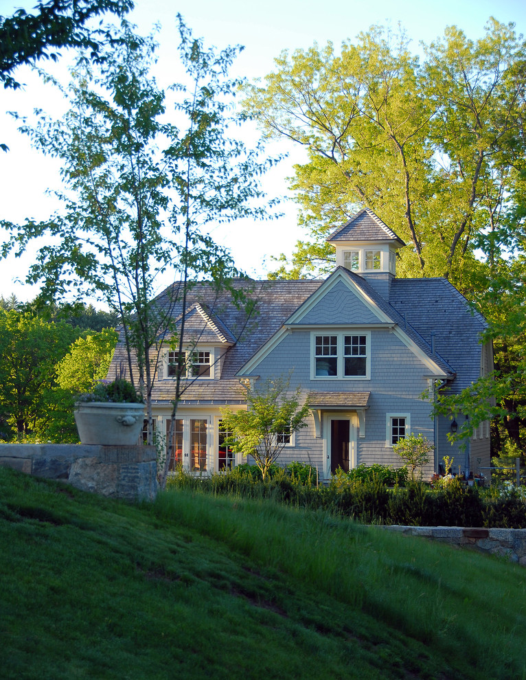 Modelo de fachada gris clásica de tamaño medio de dos plantas con revestimiento de madera y tejado a dos aguas