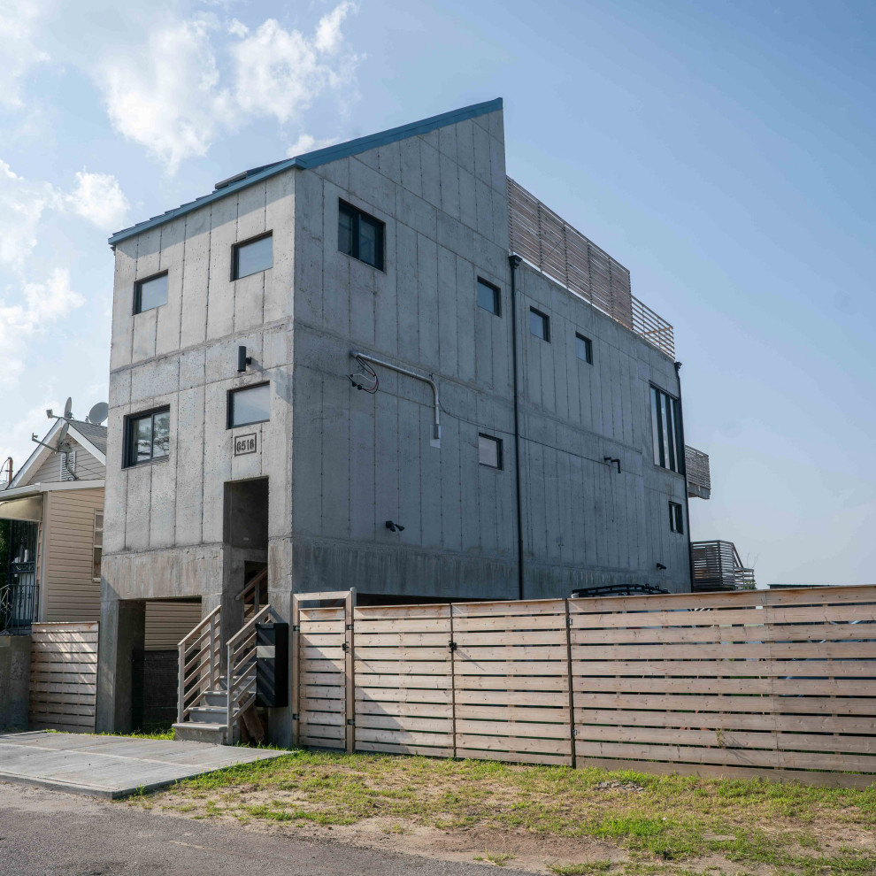 Idee per la facciata di una casa piccola grigia industriale a due piani con rivestimento in cemento e copertura in metallo o lamiera